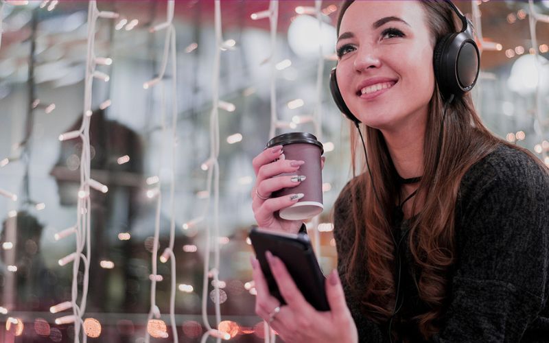 woman with headphones and coffee planning for vlogmas